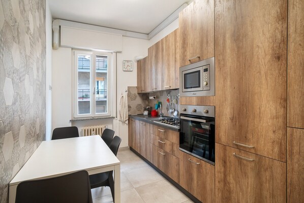 Une cuisine moderne avec des meubles en bois, un four encastré et un four à micro-ondes.