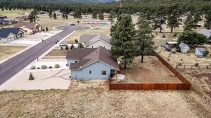 Situated on a corner lot, this two-story house offers a front yard with a fence and a paved driveway leading to the entrance.