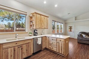Enjoy cooking in this well-equipped kitchen with a dishwasher and sink, adjacent to a cozy living area.