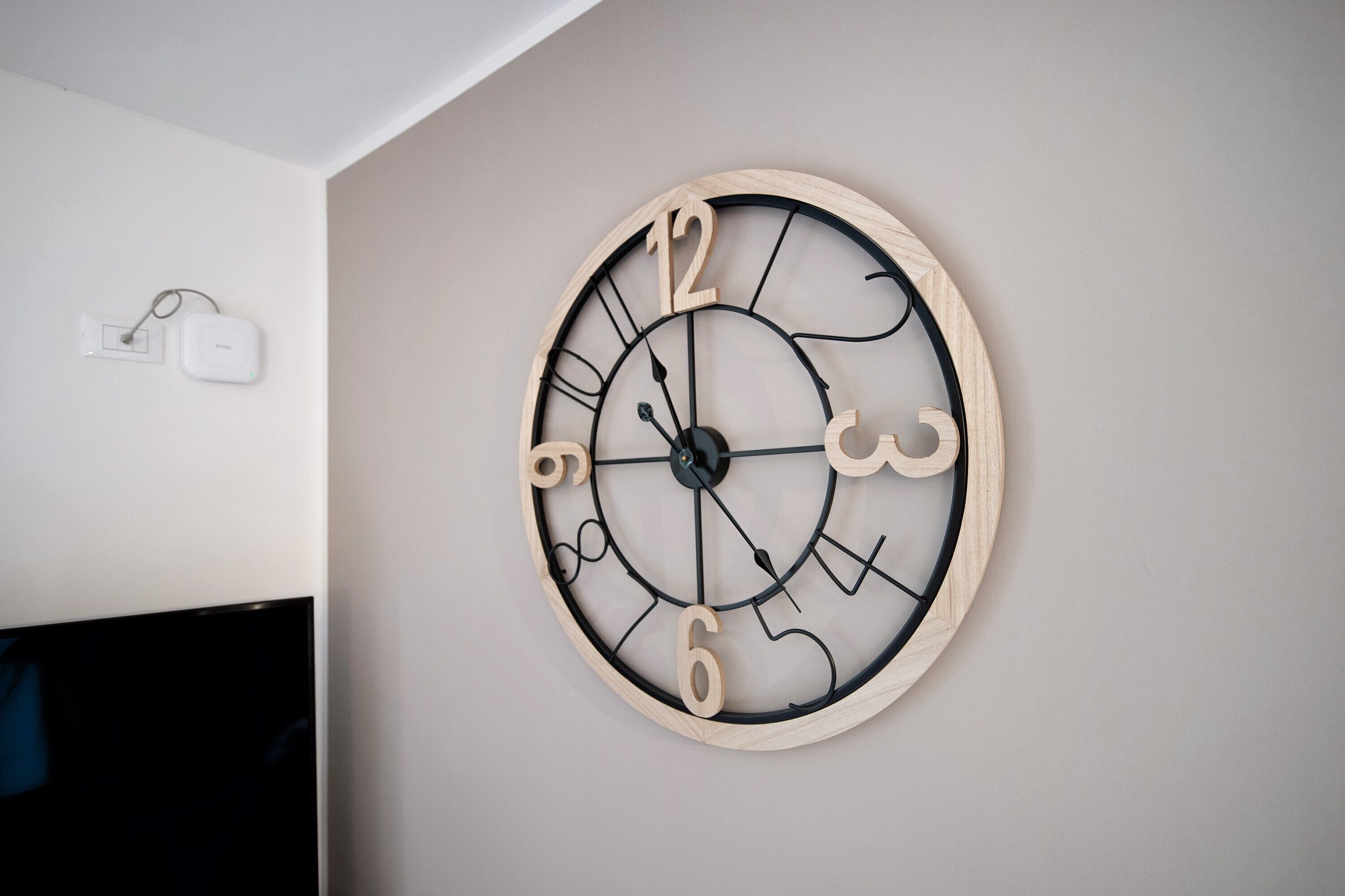 A wall-mounted wooden clock with Roman numerals.