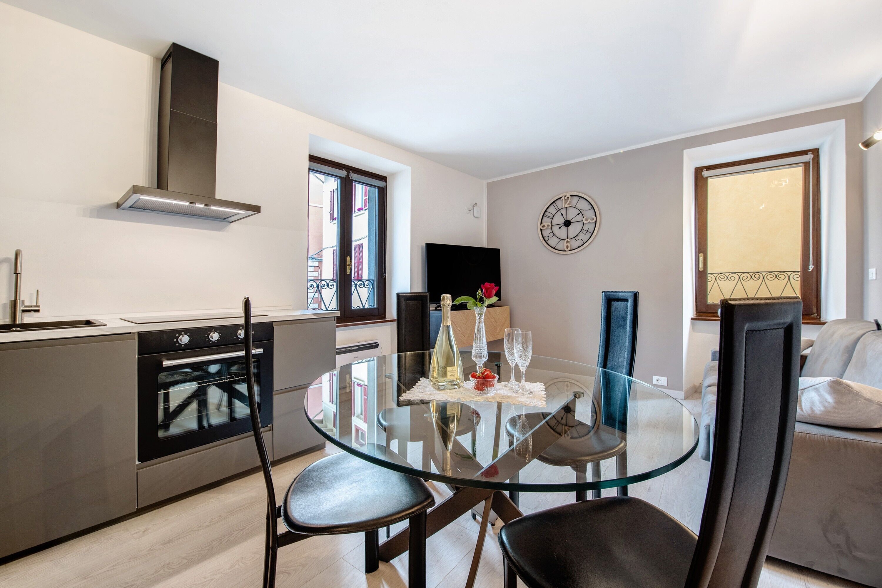 Una cocina moderna con una mesa de comedor de vidrio, electrodomésticos de acero inoxidable y un ventanal grande.
