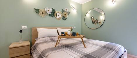 Ein Schlafzimmer mit Bett, Nachttisch und einem Wandspiegel.