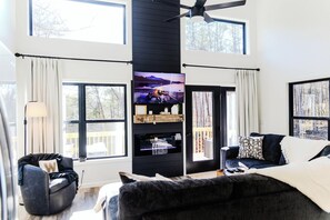 TV connectée, cheminée, livres, écrans d'ordinateur