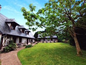 A traditional Tudor-style building with a well-maintained lawn and a large tree in the foreground. - Le Domaine des Quatre Châtaignes (SAINTE MARIE AU BOSC)