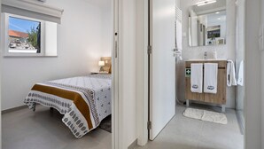 A bedroom with a bed, bedside table, lamp, and a window with a view. - Apartment 'Casinha Do Rei' with Shared Terrace, Wi-Fi and Air Conditioning (Fátima)