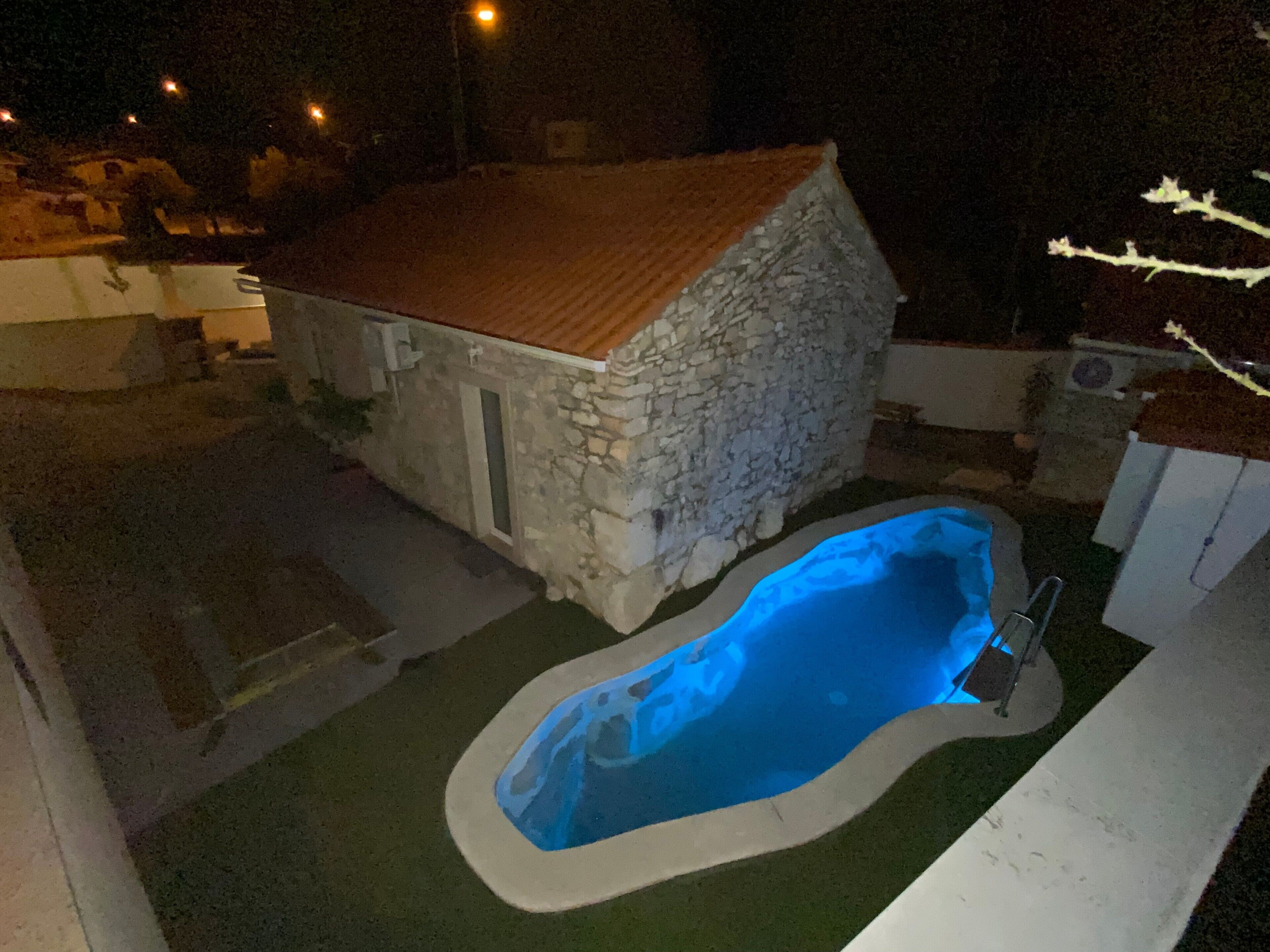 A stone house with a swimming pool.