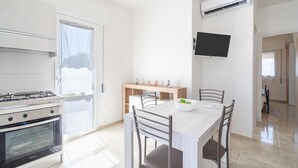 Una cocina moderna con estufa a gas, horno y comedor con mesa y sillas.