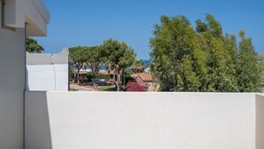 Zona residencial con un edificio blanco, árboles y un cielo azul despejado.
