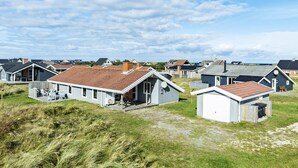 A row of beach houses with attached porches, some with satellite dishes, and a grassy area in the foreground. - Pet friendly home in Thisted with sauna (Thisted)