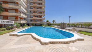 Una piscina con borde de azulejos, rodeada de un suelo adoquinado.