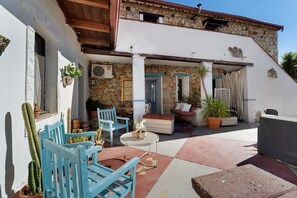 A courtyard with outdoor seating, a stone wall, and a potted plant. - Triple Room with Wi-Fi and Air Conditioning (Gonnesa)
