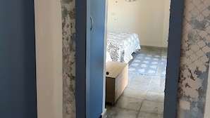 A room with a bed, a dresser, and a mirror. - Triple room with shared pool and kitchen, Wi-Fi and air conditioning (Gonnesa)