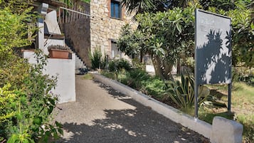 Uma trilha leva a um edifício de pedra com uma placa indicando 'Villa El Manero'.