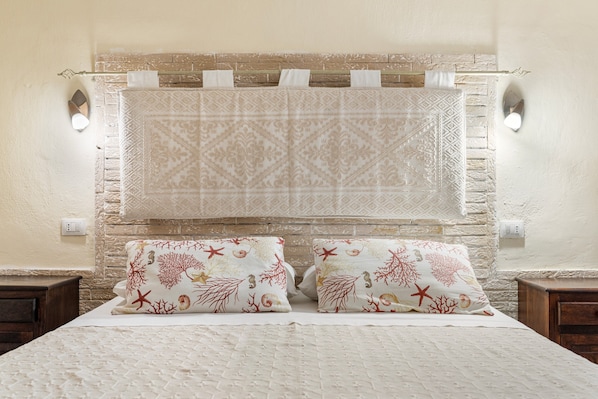 A bedroom with a bed, two pillows, a headboard, and a wall-mounted towel rack.
