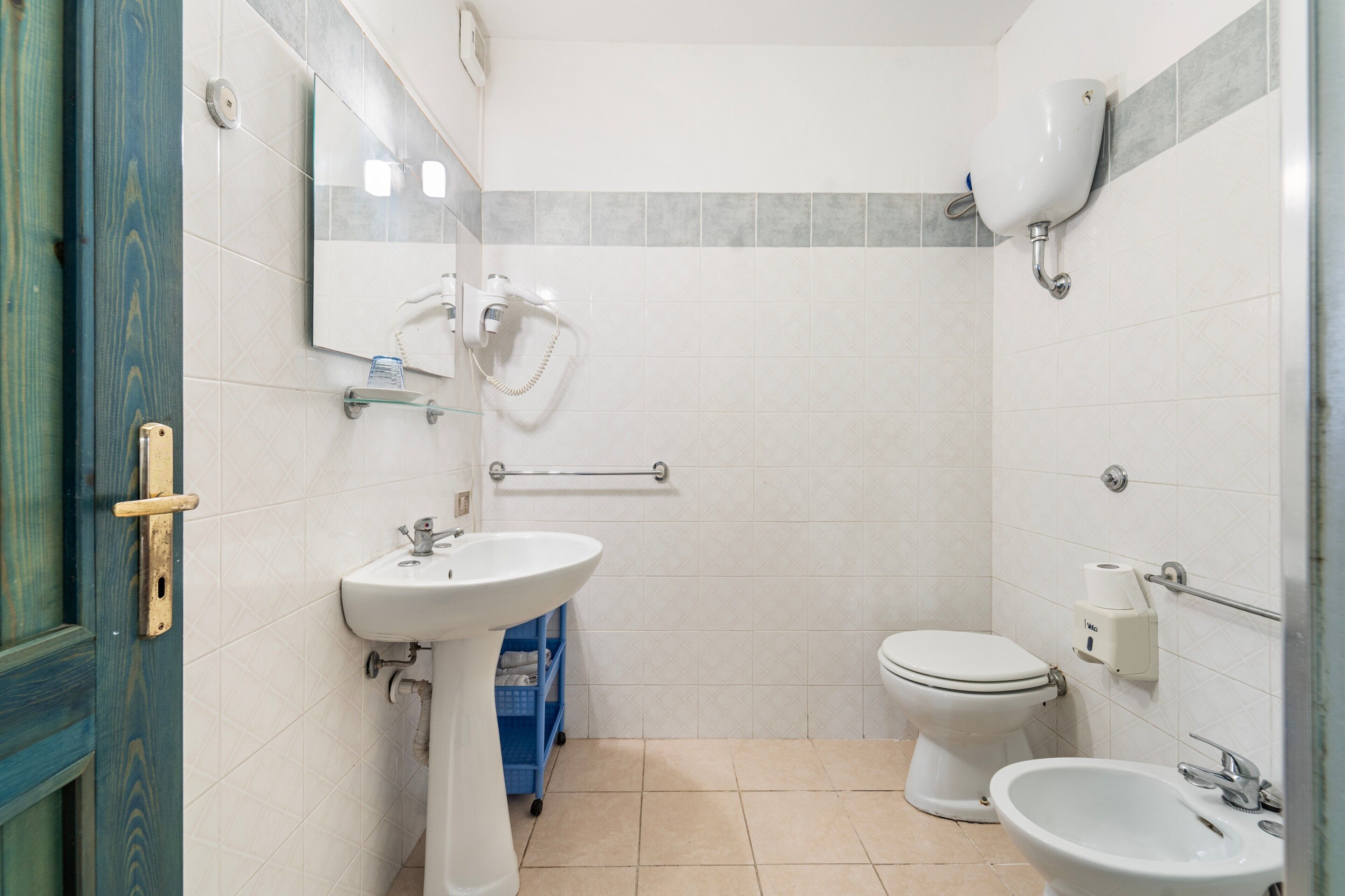 Une salle de bain équipée d’un lavabo, de toilettes, d’un bidet et d’un miroir.