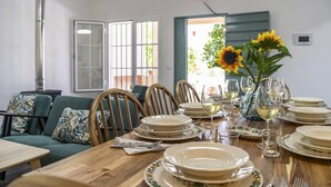 Un comedor con una mesa de madera dispuesta para una comida, rodeada de sillas.