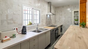 Una cocina moderna con horno empotrado, un lavamanos y una ventana.