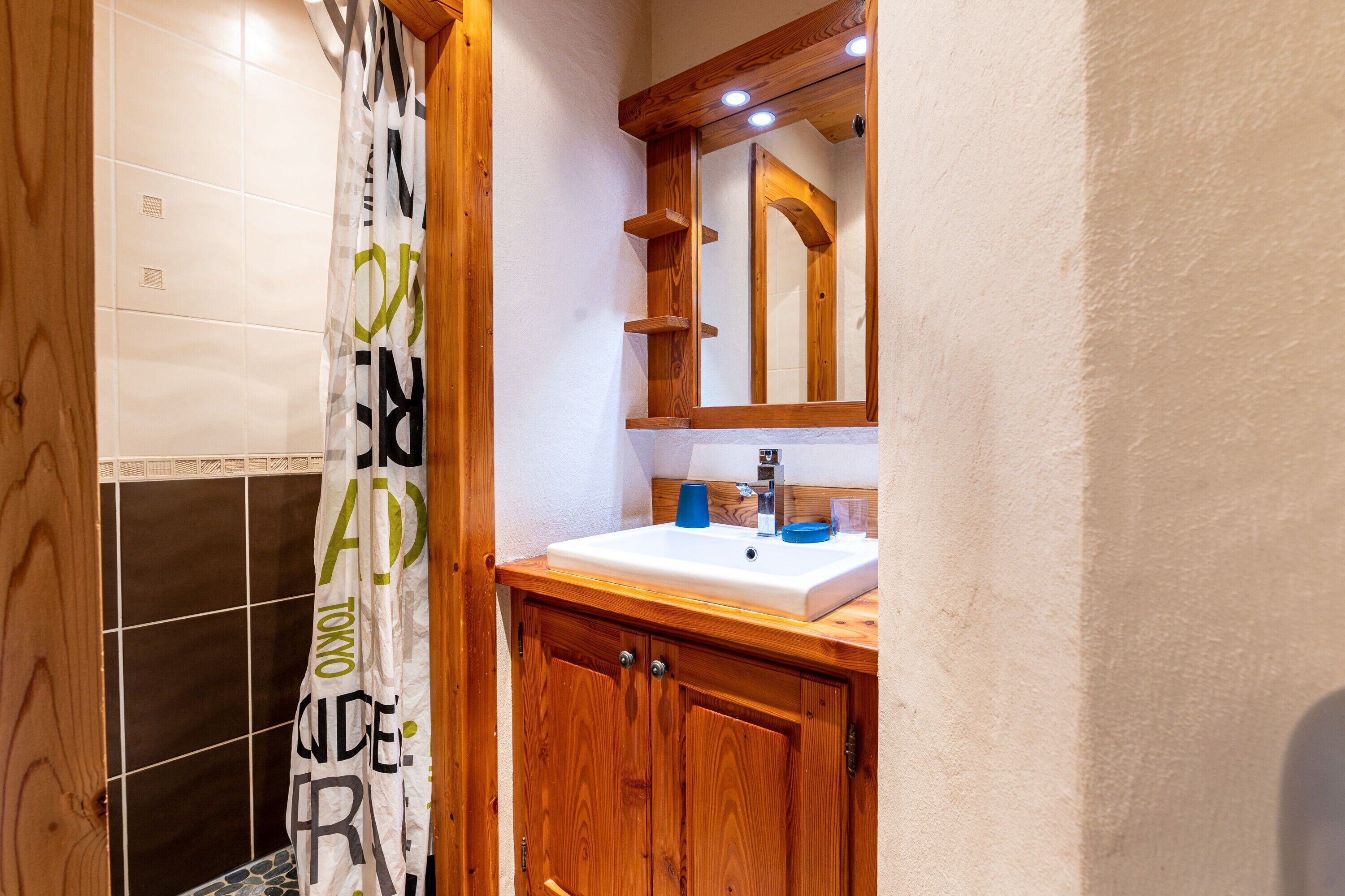 Un baño con un mueble de madera, un lavabo y un espejo.