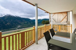 A balcony with a view of mountains, a table, chairs, and a wooden railing. - Apartment 'Heuduft' with Mountain View, Shared Garden and Wi-Fi (Lasa)