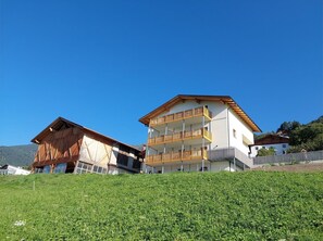 A two-story building with a wooden balcony and a sloped roof. - Apartment 'Heuduft' with Mountain View, Shared Garden and Wi-Fi (Lasa)