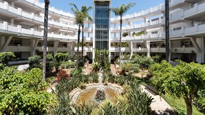 A multi-story hotel with a central atrium, palm trees, and a small water feature. - Apartment 'Parque Miraflores' with Shared Pool, Wi-Fi and Air Conditioning (Mijas)