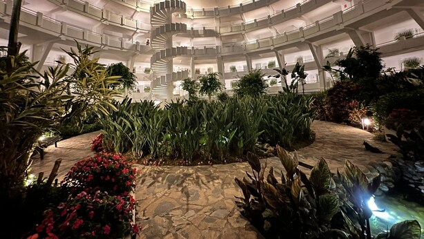A multi-level hotel with a central spiral staircase, surrounded by lush greenery and a stone pathway. - Apartment 'Parque Miraflores' with Shared Pool, Wi-Fi and Air Conditioning (Mijas)