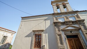 Un bâtiment doté d’un clocher, d’une fenêtre ornée de motifs métalliques complexes et d’une enseigne avec du texte.