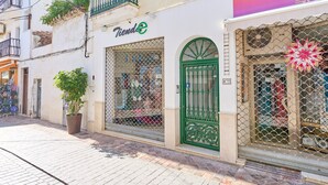 A storefront with a green gate, a potted plant, and a sign that reads 'Tienda'. - Apartment 'Apartamento B Y G Nerja' with Mountain Views, Wi-Fi and Air Conditioning. (Nerja)