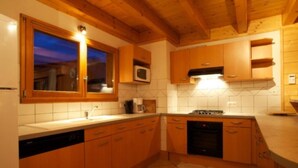 Una cocina con armarios de madera, microondas y lavavajillas.
