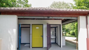 A building with a tiled roof, a yellow door, and a white wall. - Caravan 'La Pêcherie' with Private Terrace (malbosc)