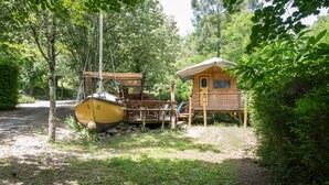 A wooden boat docked near a cabin with a deck and a small porch. - Caravan 'La Pêcherie' with Private Terrace (malbosc)