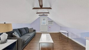 A living room with a sofa, a coffee table, and a door in the background. - Loft - Enjoy peaceful living in downtown (Kansas City)