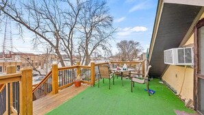 A deck with a green artificial turf, wooden railing, and a table with chairs. - Loft - Enjoy peaceful living in downtown (Kansas City)