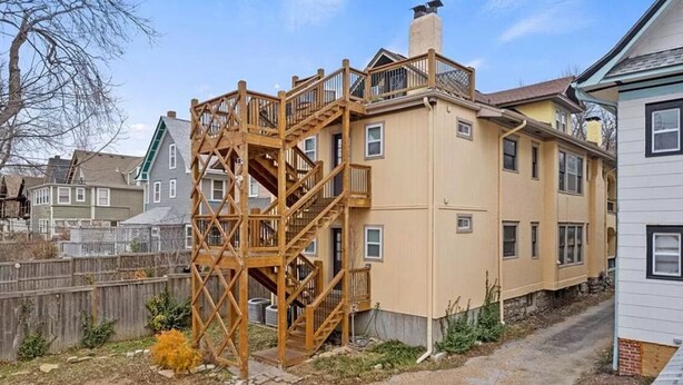 A two-story building with a wooden staircase leading to a balcony. - Loft - Enjoy peaceful living in downtown (Kansas City)