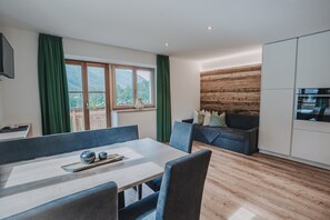 Un espacio de estar moderno con comedor, sofá y cocina.