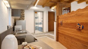 A kitchen with a modern stove, a sink, and a countertop with a coffee maker and jars.