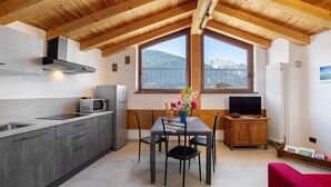 Una cocina moderna con comedor, techo de madera y vistas a montañas.