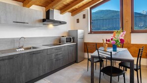 Una cocina moderna con armarios grises, un lavamanos de acero inoxidable y un microondas integrado.