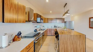 Una cocina moderna con muebles de madera, una isla central y una estufa empotrada.