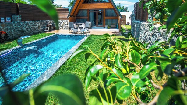 A modern house with a swimming pool, stone walls, and a wooden deck. - Gezegen Bungalow (Sapanca)