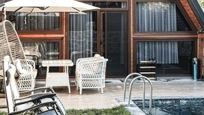 A modern house with a triangular roof, large windows, and a swimming pool. - Gezegen Bungalow (Sapanca)