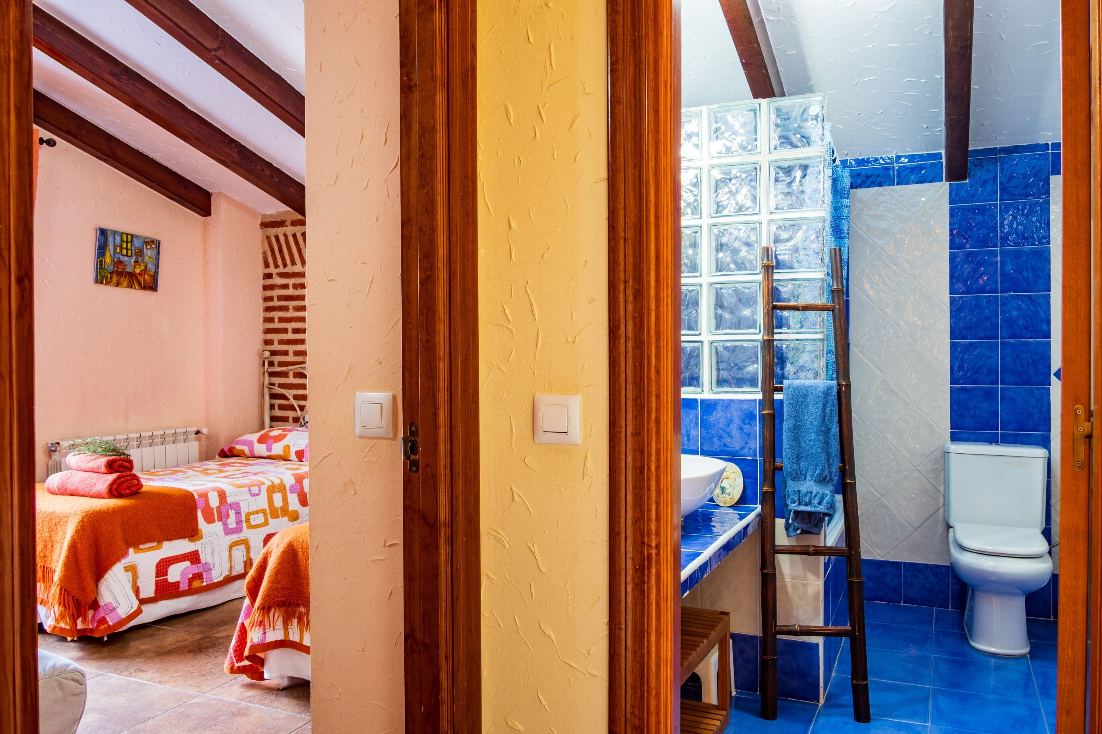 Een slaapkamer met een bed, een badkamer met toilet en wastafel, en een raam met uitzicht.