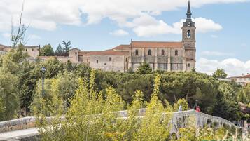 Un edificio storico con una torre imponente e un muro in pietra sullo sfondo.