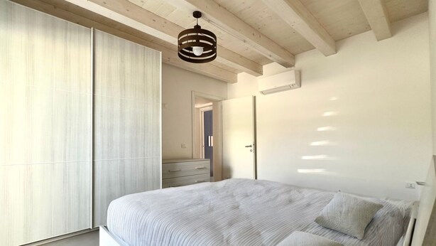 Una camera da letto con un letto, un armadio e una porta scorrevole.
