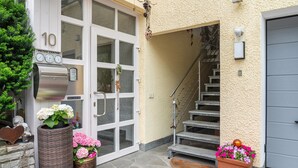 A building entrance with a number '10' sign, a mailbox, and a staircase leading to a garage.