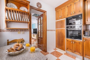 A kitchen with wooden cabinets, a microwave, and a double oven.