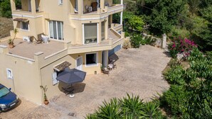 Un edificio a più piani con balconi, posti a sedere all'aperto e un patio lastricato.