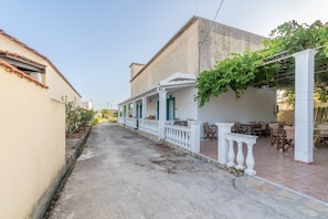 Un vicolo stretto con un edificio dotato di un portico e posti a sedere all'aperto.
