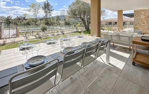 Enjoy al fresco dining on the terrace with a view of the lush landscape and distant hills.