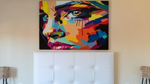 A room with a large, colorful abstract painting on the wall, a tufted headboard, and two floor lamps. - Apartment 'Reserva Marbella' with Shared Pool, Wi-Fi and Air Conditioning (Marbella)
